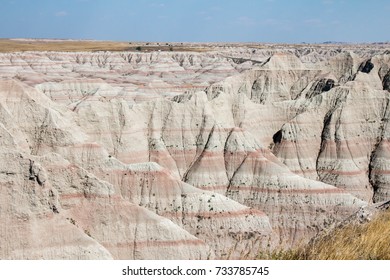 Tan Sandstone Cliffs With Pink Lines In The Badlands National Park 