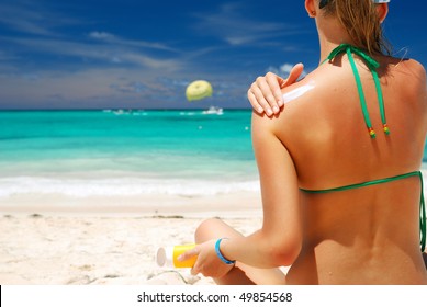 Tan Woman Applying Sun Protection Lotion