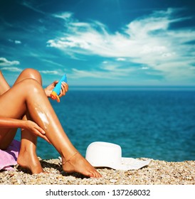 Tan Woman Applying Sunscreen on Legs - Powered by Shutterstock