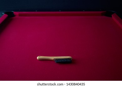 Tan Wooden Pool Table Cleaning Brush On A Red Felt Billiards Table.