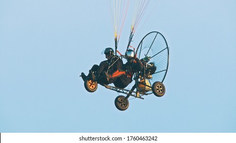 Tandem Paramotor Gliding - two men flying and gliding in the air. High quality photo