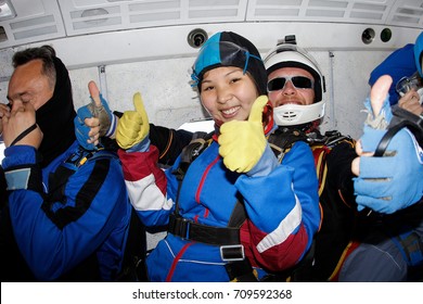 Tandem Skydiving. Asian Girl Is In The Airplane. She Is Going To Jump.