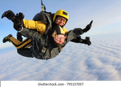 Tandem skydiving. Girl is a passenger.