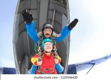 Tandem Skydiving. Man And Woman Are Jumping Out Of A Plane.