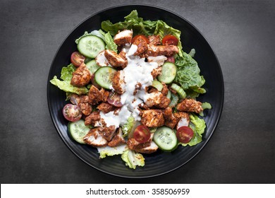 Tandoori chicken salad, overhead view on black slate.