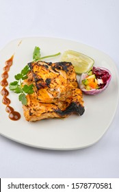 Tandoori Salmon Tikka - Traditional Indian Starter Garnished With Coriander And Lemon Wedge And Served With Salad