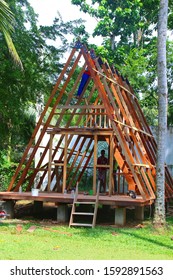 TANGALLE, SRI LANKA, ASIA - November 7, 2019. Professional Sri Lankan Construction Builders Are Building Tiny Wooden Cottage House With Pointed Roof For Holiday Vacation In Tropical Gardens. 