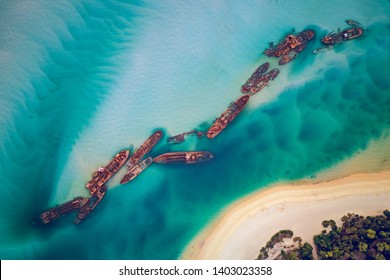 The Tangalooma Wrecks used to be 15 steam driven barges which were deliberately sunk in 1963 along the Moreton Island coastline to form a breakwall so that small boats can anchor in shelter. - Shutterstock ID 1403023358