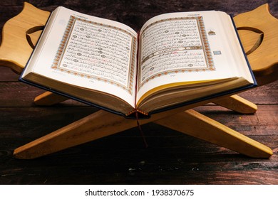 Tangerang Selatan, Indonesia - March 15, 2021: An open page of Quran shows Surah Al Kahf on brown background. Selective focus.