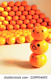 Tangerine and face drawn and three oil  based pens piled up against the background large amount oranges