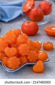 Tangerine Jellies. Homemade  Orange Jelly Candys Made From Clementine Juice And Gelatin. Heart And Flower Shaped Gummy Sweets Served On A Plate With Fresh Clementines On Background. Vertical.