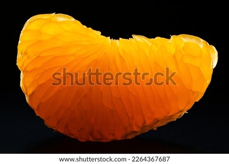 Tangerine pulp close up on black background. Peeled mandarin slice macro photo. Citrus fruit flesh texture. Clementine slice isolated on black background