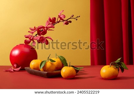 Tangerines displayed on wooden dish and a flower pot decorated on red surface. During Chinese New Year, red is said to symbolize luck and happiness
