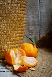 Tangerines Or Mandarin Oranges (Citrus Reticulata) Are Oranges That Can Grow In Tropical And Subtropical Areas, Randomly Some Are Whole, Some Have Been Cut, With A Natural Wood And Woven Background