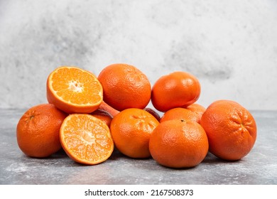 Tangerines (oranges, mandarins, clementines, citrus fruits) with leaves over rustic white stone background with copy space front view, Fresh mandarin orange fruit or tangerines, mandarins oranges.