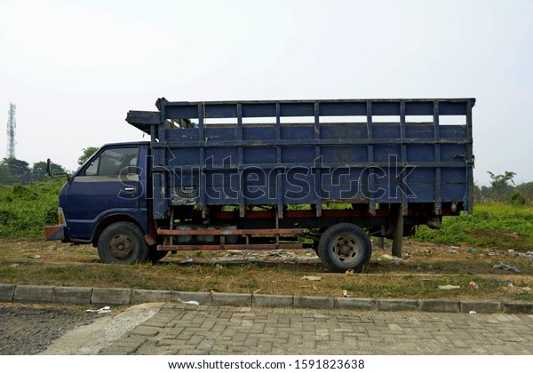 Tanggerang Indonesia - October\
2019: A blue truck carrying goods is being parked on empty ground\
awaiting an order to transport goods. Location in\
Tangerang.