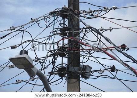 Tangle of cables on electricity pylons. Cable clutter on an street power pole in Manaus, where overhead power lines are the norm, Amazonas state, Brazil.