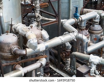 Tangle Of Pipes. Concept Of Complexity Of Petrochemical Industry Communications. Pipe Weaving Of Various Diameters With Expansion Joints And Flanges Heat Exchanger Boilers.