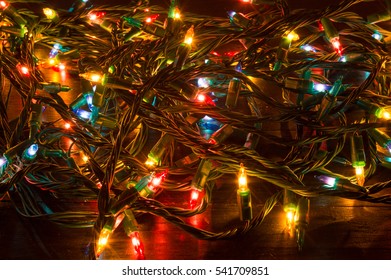 Tangled Christmas lights shining on a table