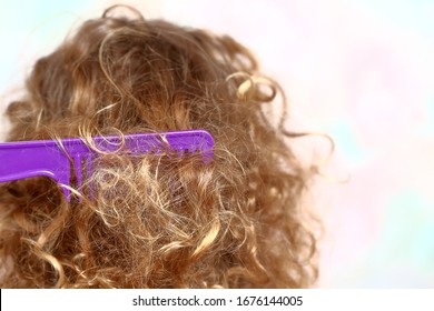 Tangled Comb In Blond Curly Hair