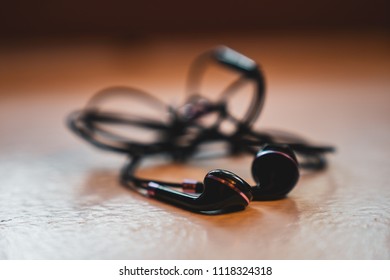  Tangled Earbuds Closeup On White Surface
