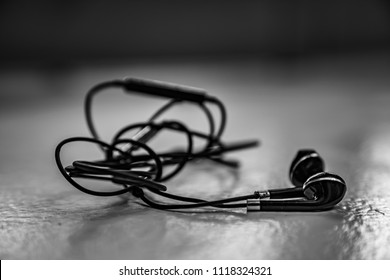  Tangled Earbuds Closeup On White Surface
