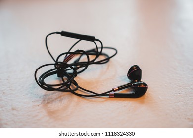  Tangled Earbuds Closeup On White Surface
