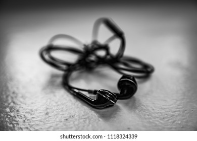  Tangled Earbuds Closeup On White Surface
