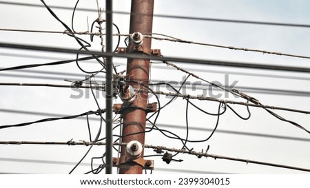 Tangled electrical cables.  In Indonesia.  Unsafe, dangerous.  Not neat