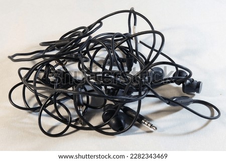 Tangled headphone wires for phone close-up on white background