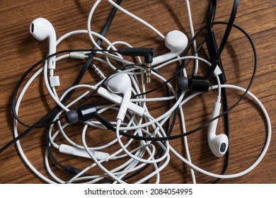 Tangled Headphones On Wooden Table