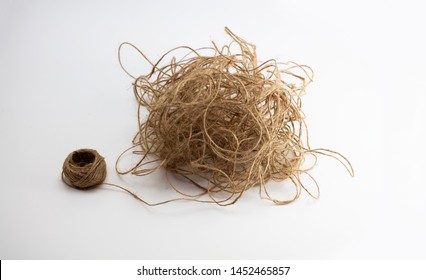 Tangled Mess. Unorganized, Stress, Confused, Complicated, Concept Image. Reel Of Hemp String And A Large Ball Of Tangled Hemp String Isolated On Neutral White Background.