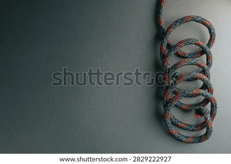 Tangled rope arranged in overlapping loops on dark background with large copy space, representing confusion, complexity, disorder and entanglement