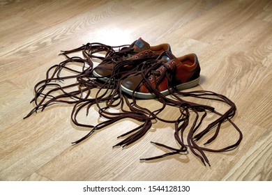 Tangled Shoelaces On The Wooden Floor