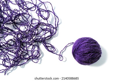 Tangled threads with a ball lie on a white background.