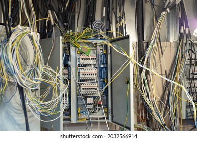 Tangled wires in electrical cabinet. Electric and mains wires are tangled. Concept - adjustment of power grid. open electrical cabinet with tangled wires. Electrification adjustment.