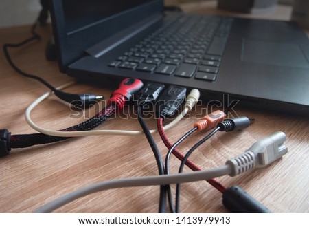 tangled wires. usb mess cabel. laptop cords on a wooden table