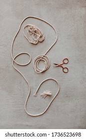 Tangled Yarn With Rose Gold Scissors On Grey Background