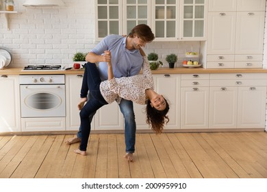 Tango Barefoot. Romantic Millennial Couple In Love Dance On Warm Heated Floor At Large Light Modern Kitchen Distracted From Cooking Food. Passionate Loving Man Woman Have Date At Home Celebrate Event