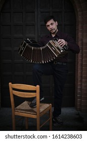 A Tango Man Holding A Bandoneon While Standing.