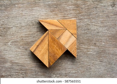 Tangram Puzzle In Arrow Shape On Wooden Background