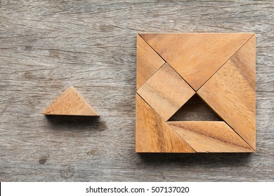 Tangram puzzle wait for fulfill to square shape on wooden table