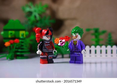 Tangsel, Indonesia-July 2 2021: Joker Give Bunch Of Flower To Harley Quinn. Lovely Villain Couple. Little Green Garden Behind Them. Lego Minifigures Are Made By The Lego Group