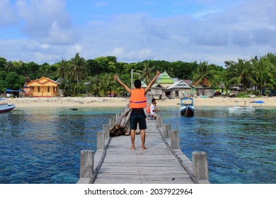 Tanjung Bira, Indonesia - February 20, 2021 : On a very long beach pier and a small island