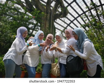 Tanjung Bungah, Penang, Malaysia - 18 July 2019: A Group Of Malay Girl Best Friends Wearing Hijabs Laughing And Pointing At A Butterfly Perched On A Finger. Taken At Entopia By Penang Butterfly Farm