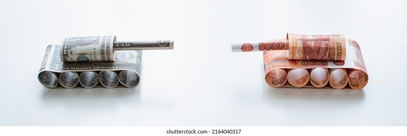 Tank Of Dollar And Ruble Banknotes On A White Table Background. Bills. The Concept Of Arms Supply, Purchase And Sale Of Firearms, America Vs. Russia, Crumpled Money