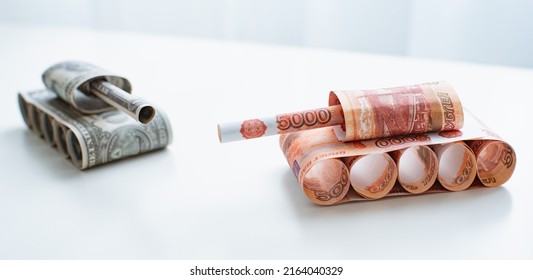 Tank Of Dollar And Ruble Banknotes On A White Table Background. Bills. The Concept Of Arms Supply, Purchase And Sale Of Firearms, America Vs. Russia, Crumpled Money