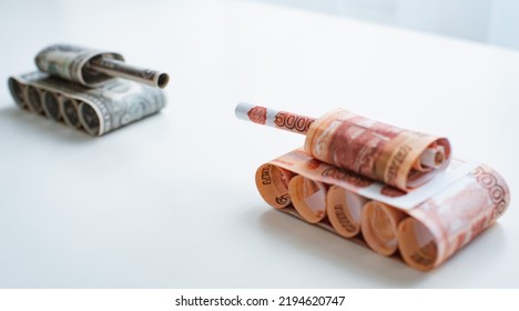 Tank Of Dollar And Ruble Banknotes On A White Table Background. Bills. The Concept Of Arms Supply, Purchase And Sale Of Firearms, America Vs. Russia, Crumpled Money