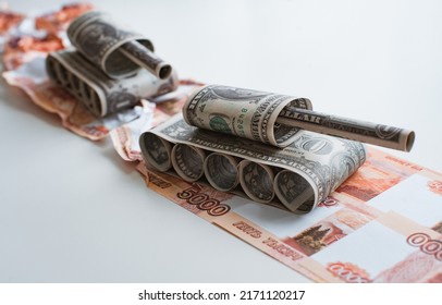 Tank Made Of Dollar Bills Rides On A Road Made Of Ruble Banknotes Bills. The Concept Of Arms Supply, Purchase And Sale Of Firearms, America Vs. Russia, Crumpled Money