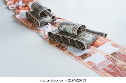 Tank Made Of Dollar Bills Rides On A Road Made Of Ruble Banknotes Bills. The Concept Of Arms Supply, Purchase And Sale Of Firearms, America Vs. Russia, Crumpled Money